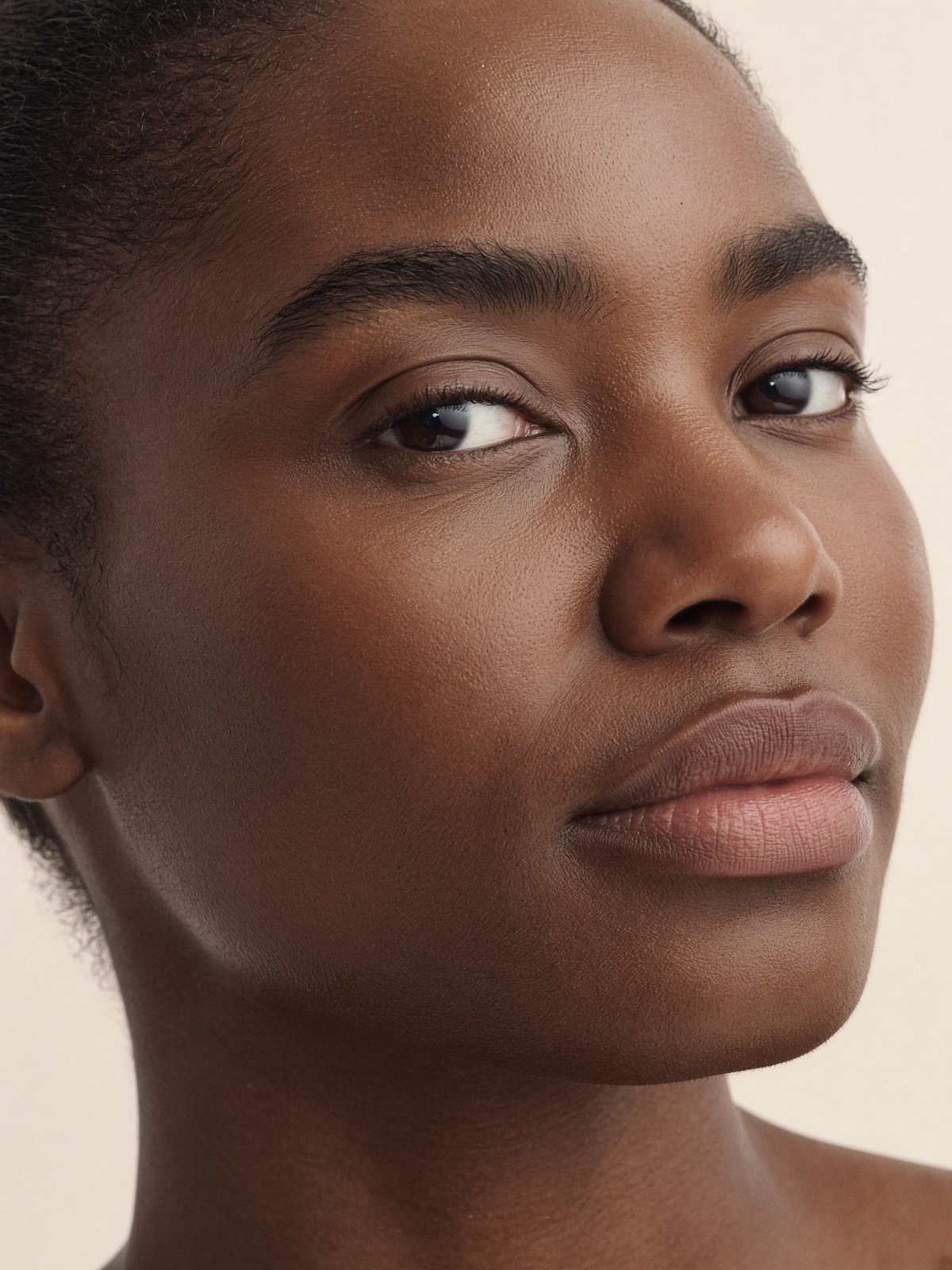 Editorial portrait, melanin-rich phototype, hair off the face.